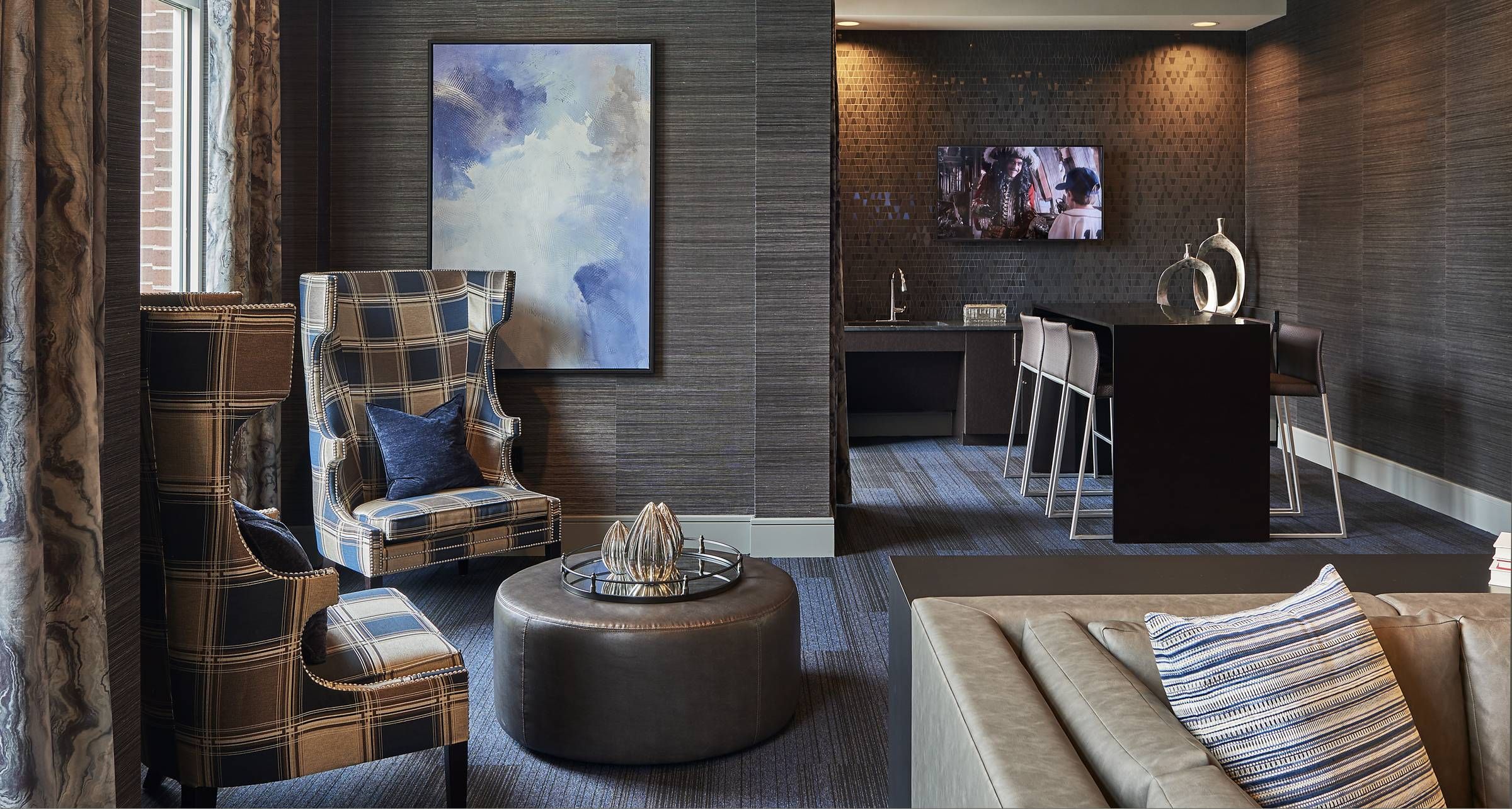 Evolution at Towne Center Laurel clubhouse lounge area with modern-style furniture and TV.