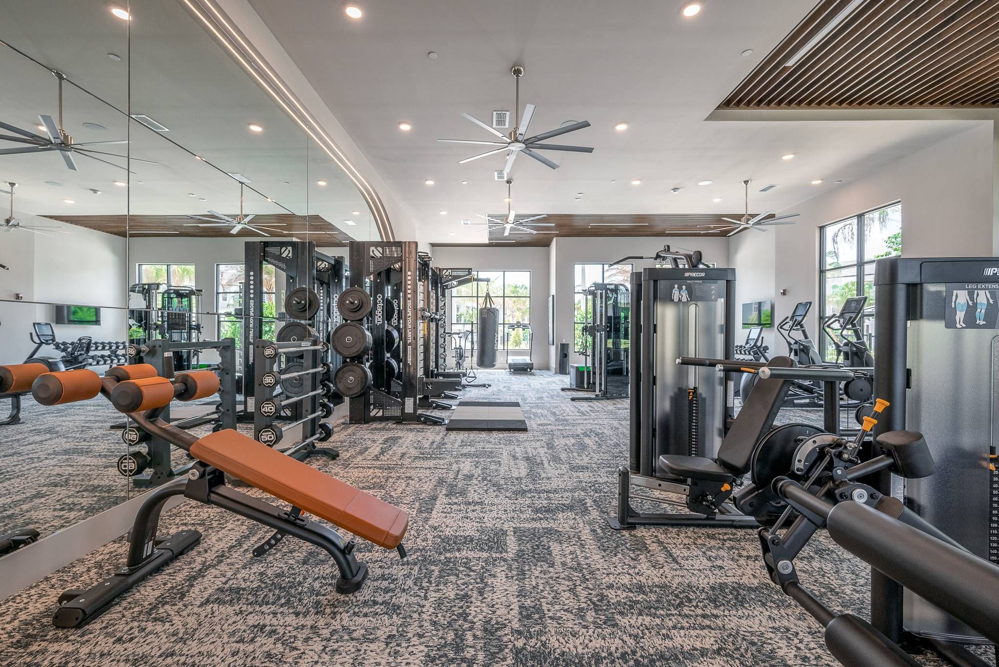 A spacious, well-equipped gym with multiple workout stations and large ceiling fans at Alta at Horizon West.