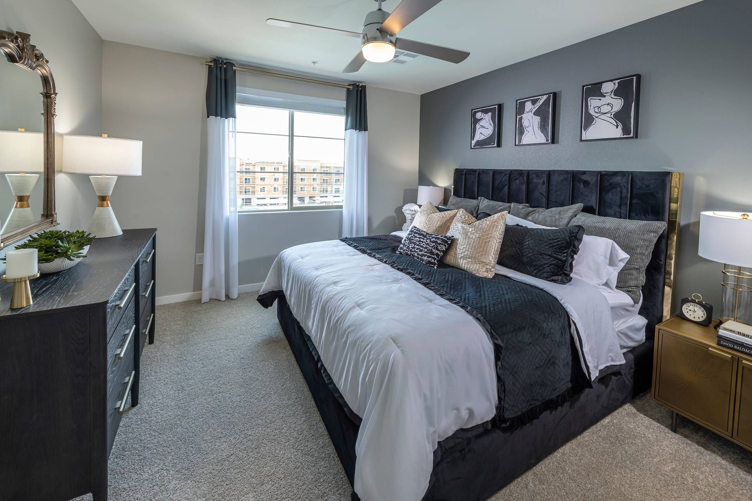 Alta Southern Highlands offers a bedroom with a luxurious black bed, matching dressers, and elegant wall art.